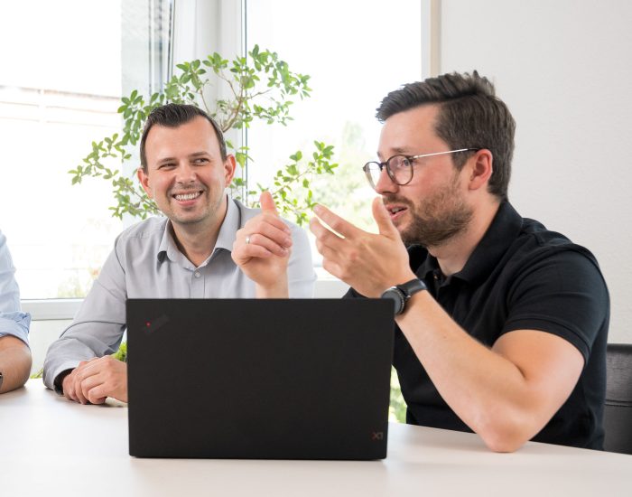 Zwei Personen an Laptop