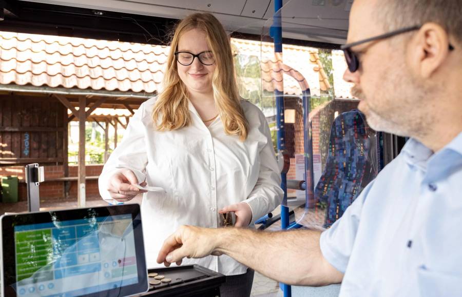 Frau kauft Ticket im Bus